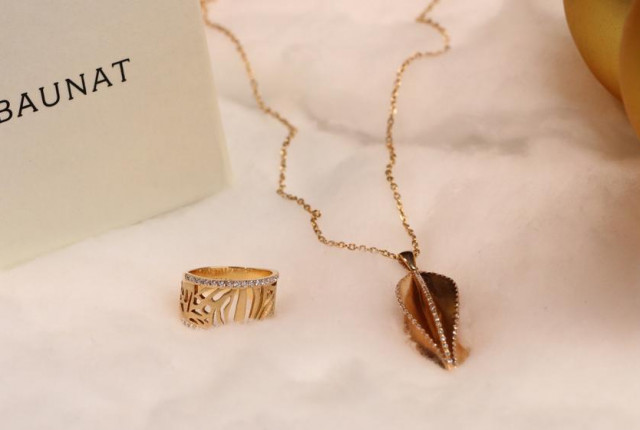 Gouden ring met opengewerkt patroon en pavé diamanten naast een roségouden bladvormige hangerketting Vind het juweel naar uw wens bij BAUNAT.