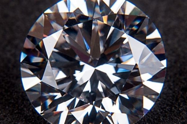 Close-up van een ronde briljant geslepen diamant op donkere achtergrond