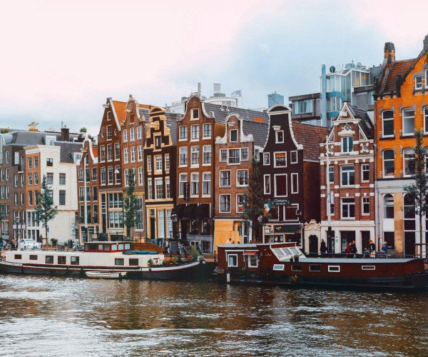 Uitzicht op Amsterdamse grachten met historische trapgevels en woonboten aan het water