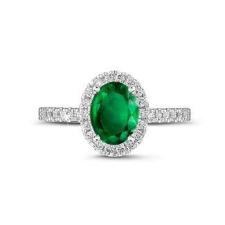 Verloving - Halo solitaire ring in wit goud met een ovale smaragd en ronde diamanten