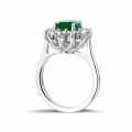 Entourage ring in wit goud met ovale smaragd en ronde diamanten