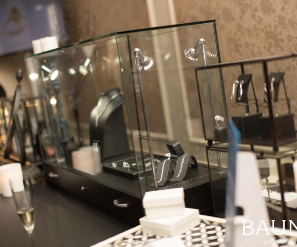 Juwelen in glazen vitrines met witgouden ringen en diamanten oorbellen in een elegante showroom