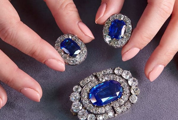 Evde bir kutuda güvenle saklanan safir pırlanta mücevherleri sergileyen manikürlü tırnaklı eller